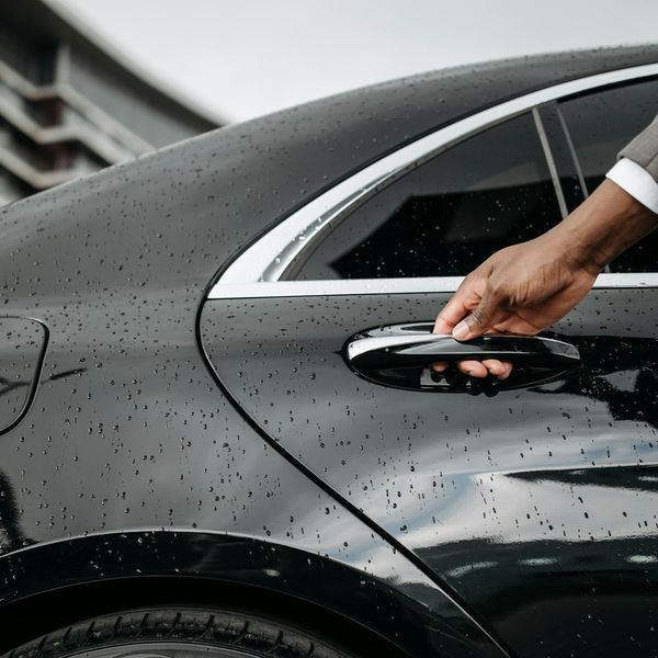 Professional technician polishing luxury car exterior